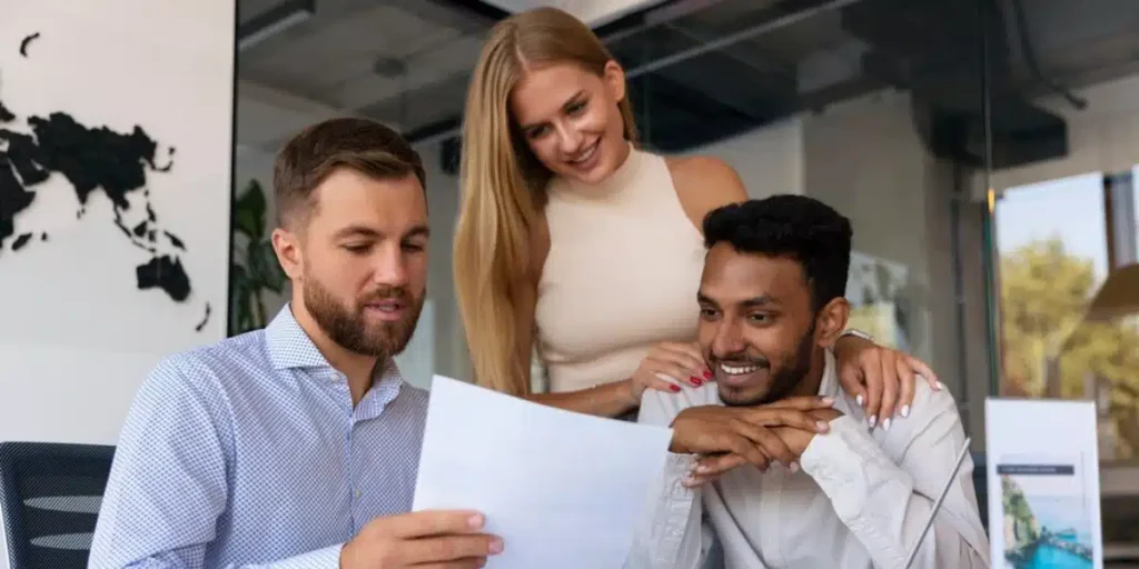 Um homem está sentado, segurando alguns papeis referentes a benefícios corporativos