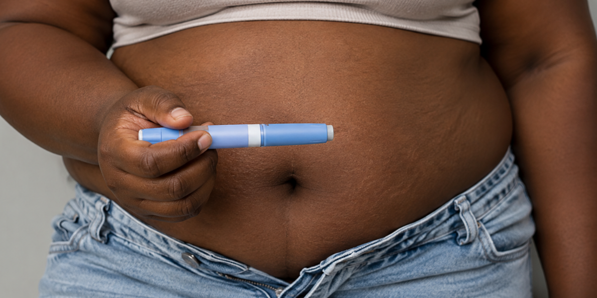 mao segurando caneta azul aplicado na barriga grande