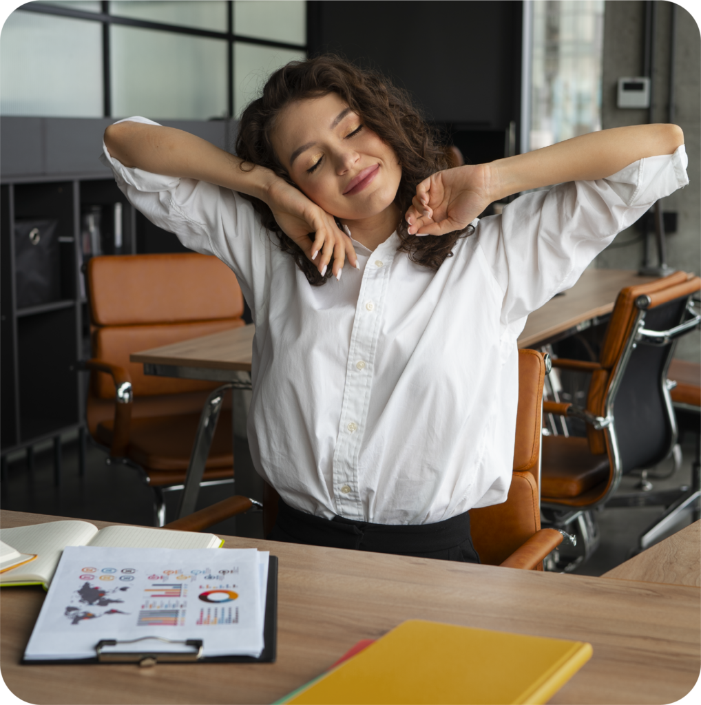 Mulher sorridente fazendo pausa e alongamento no escritório, representando bem-estar no trabalho e prevenção do burnout.