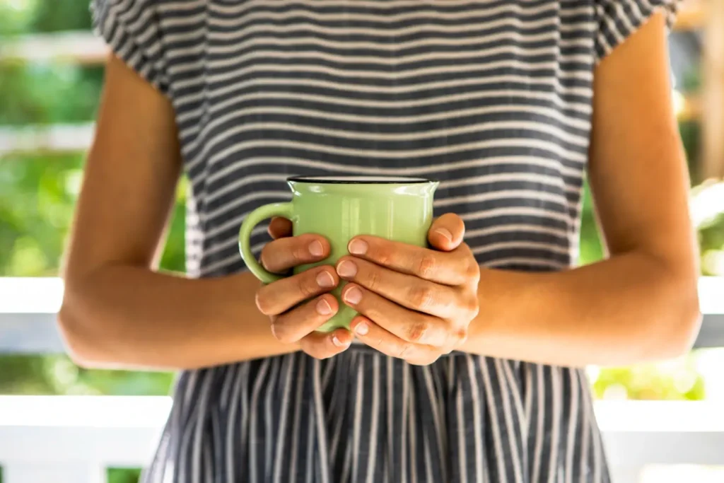 Mulher segurando xícara de chá verde simulando uma alimentação funcional