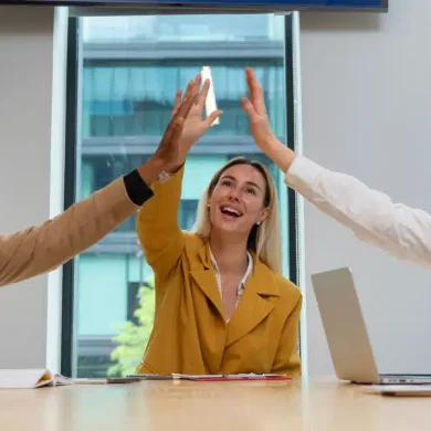 empreendedores sentados em uma mesa comemorando que conseguiram aumentar as vendas telecom