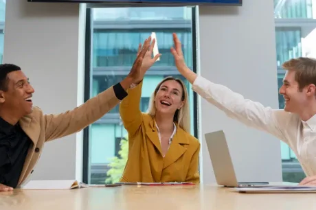 empreendedores sentados em uma mesa comemorando que conseguiram aumentar as vendas telecom