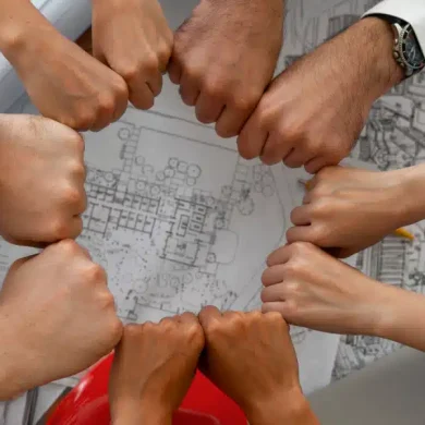 colaboradores de uma empresa com as mãos unidas em prol de um objetivo único. Isso garante que o clima organizacional da empresa está em bons níveis, porque demonstra a união da equipe e a satisfação do time
